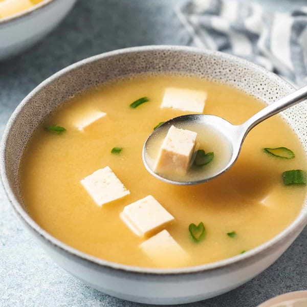A close-up of a bowl of Sogo Hibachi and Sushi Lounge's miso soup with tofu and green onions.