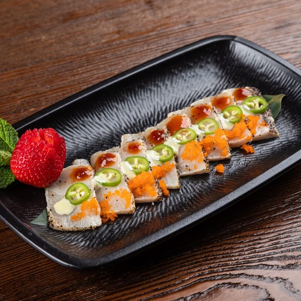Sogo Hibachi and Sushi Lounge's seared tuna sashimi with roe, jalapeños, sauce, and a carved strawberry.